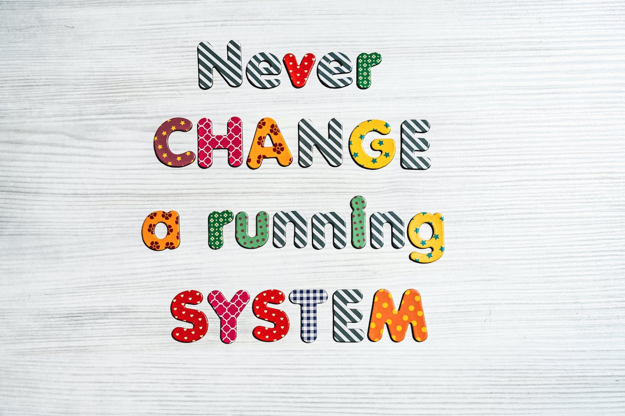 Inspirational quote Never change a running system in vivid letters on a wooden surface.