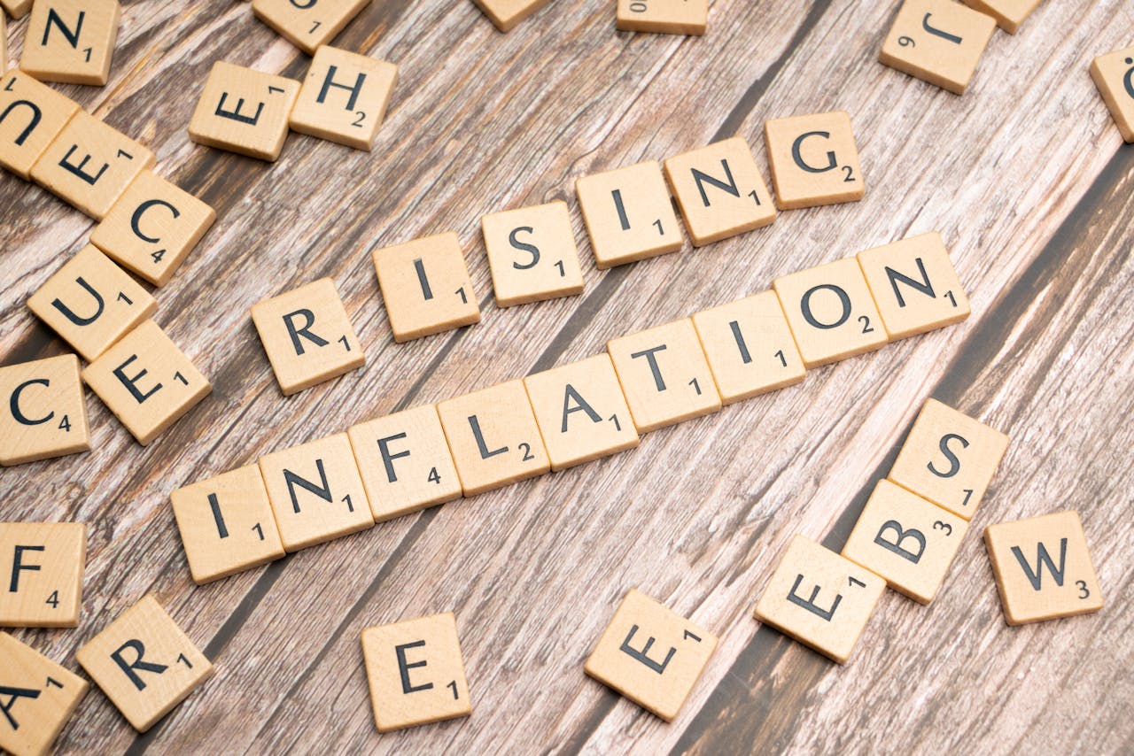 Wooden letter tiles spell rising inflation symbolizing economic concerns.